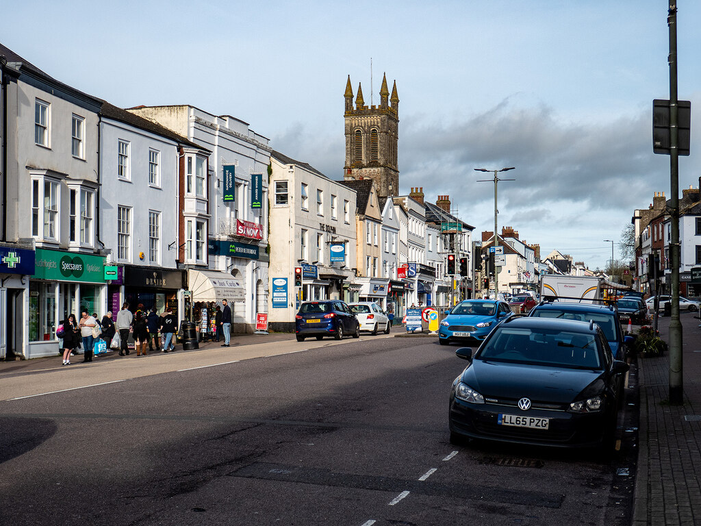 High Street, Honiton in East Devon with shopfronts and parked cars along the main road